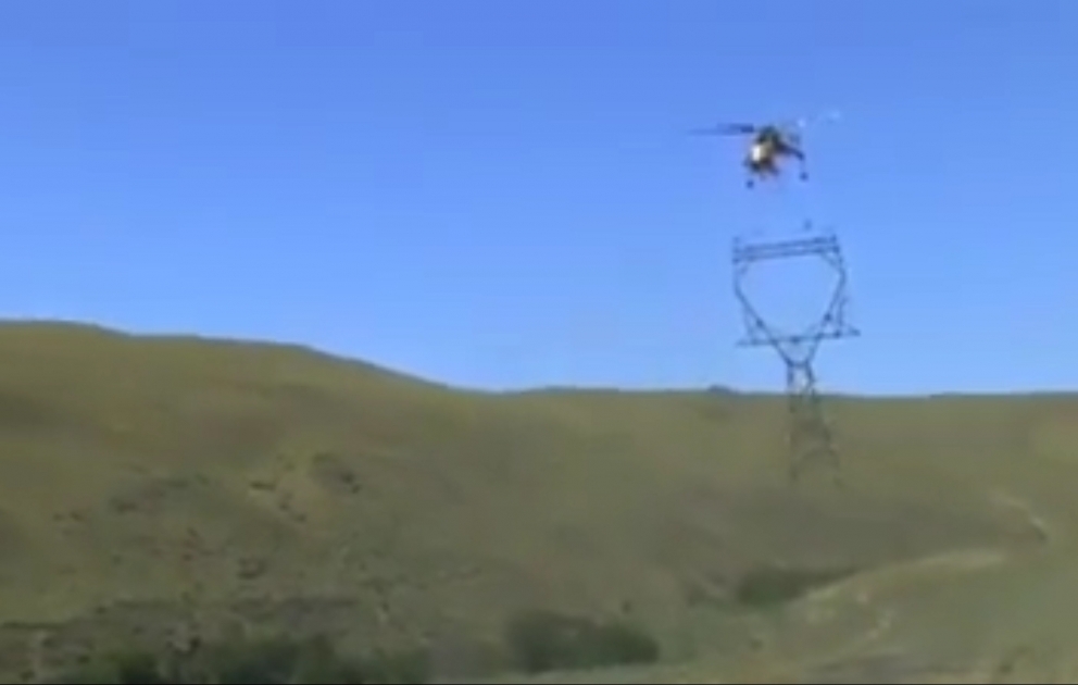 Helicopter installing high tension power poles