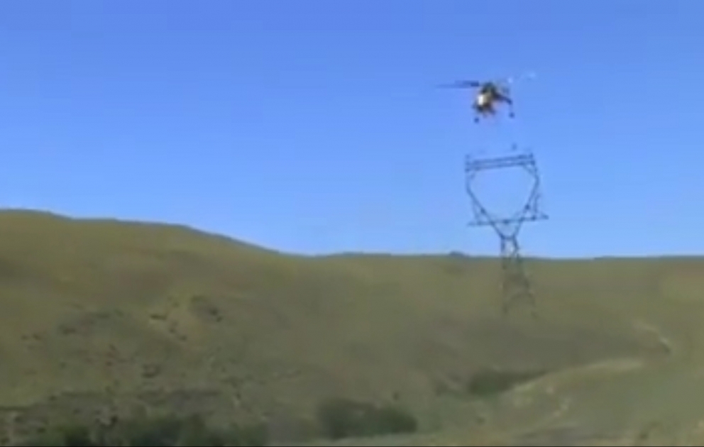 Elektrische Säulen werden in den Bergen mit Hubschrauber installiert