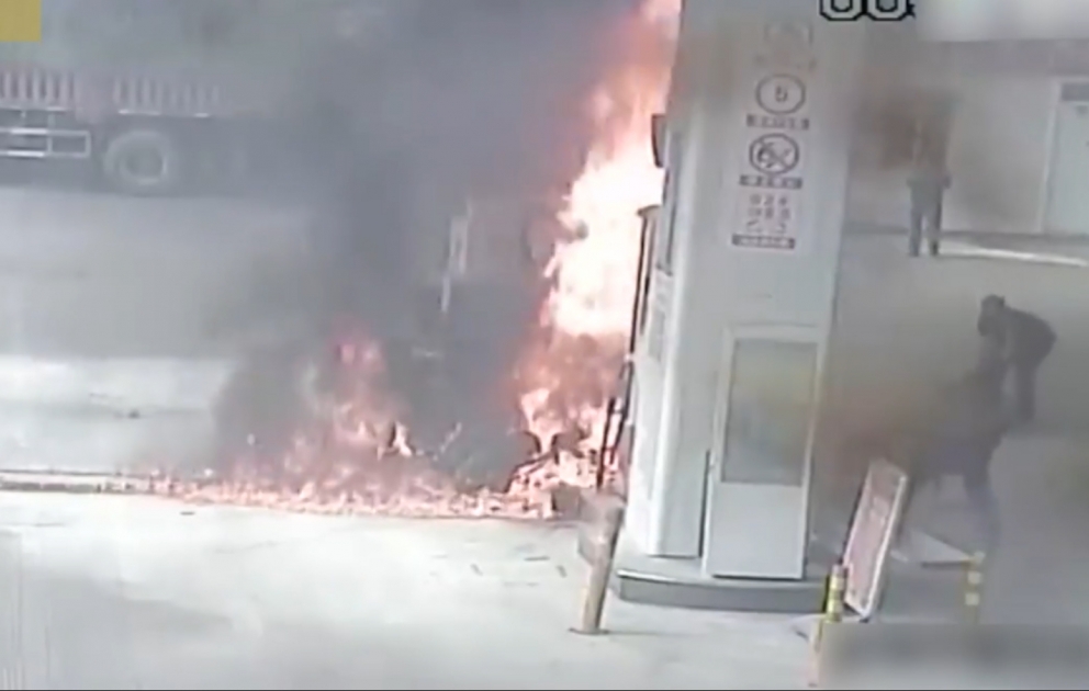 Oil suppliers put out fire on a motorcycle in a gas station in SW China