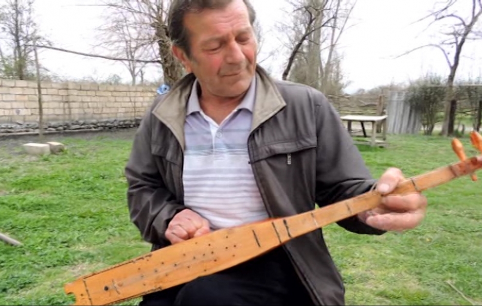 Bir əli ilə tənbur alətləri düzəldən usta