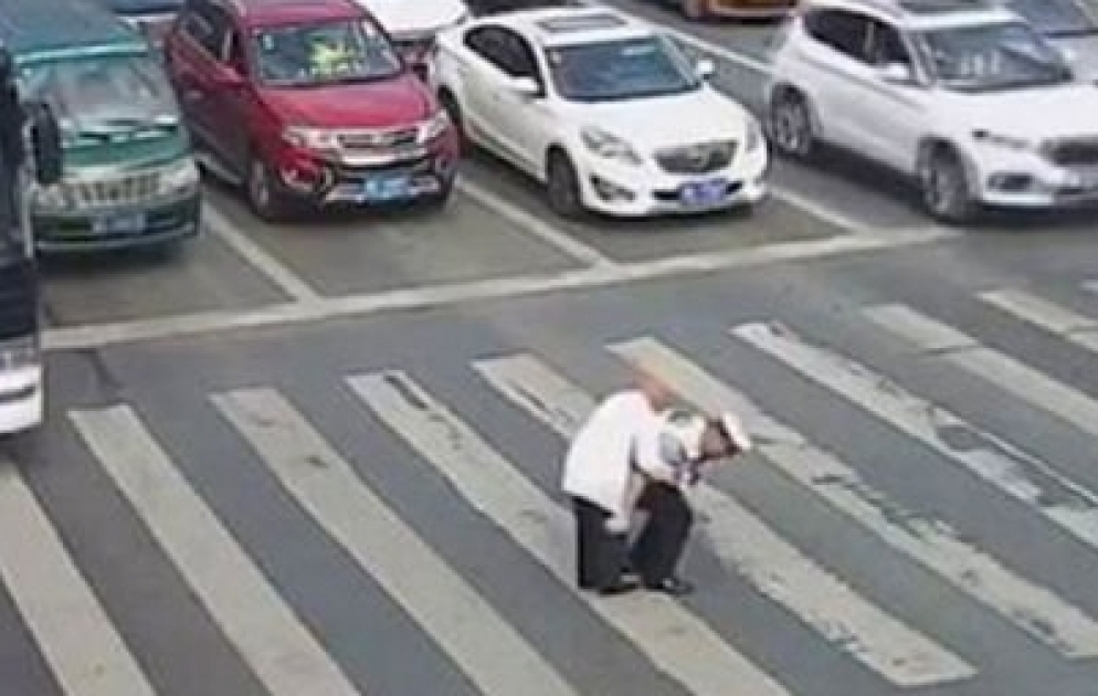 Polis yaşlı kişini belinə alıb yolu keçirdi