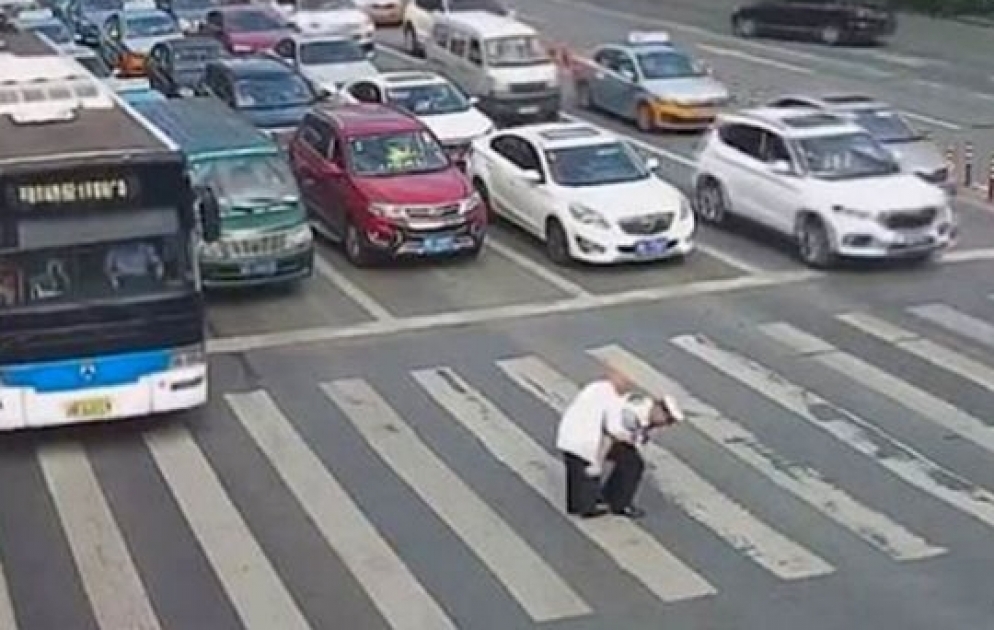 Police officer piggybacks elderly man across busy road