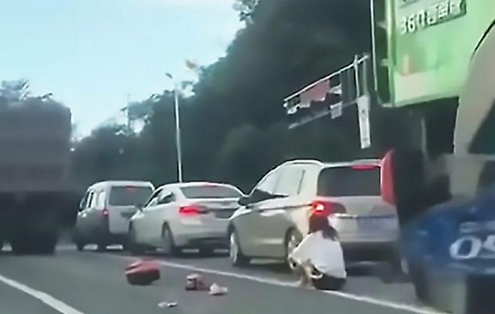 Çinli motosikletçi yük maşınının altından sağ çıxdı