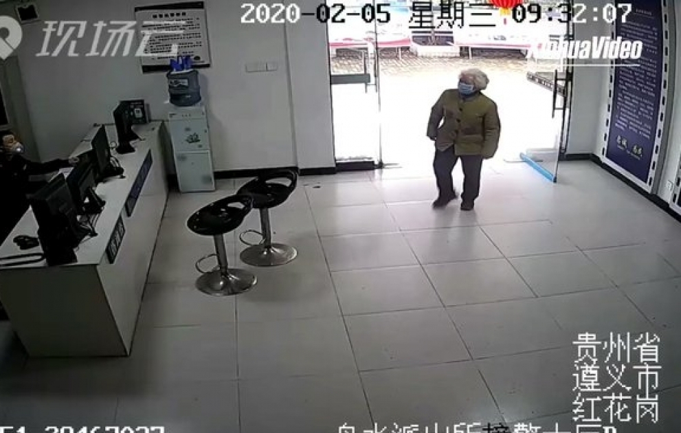 An elderly woman hands over a stack of cash to police officers in Zunyi, China, and leaves in tears