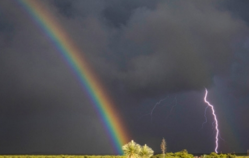 Lightning strikes through rainbow during thunderstorms in Oklahoma