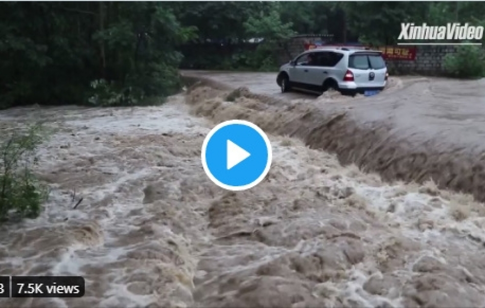 Водитель застрял в своей машине посреди затопленной дороги