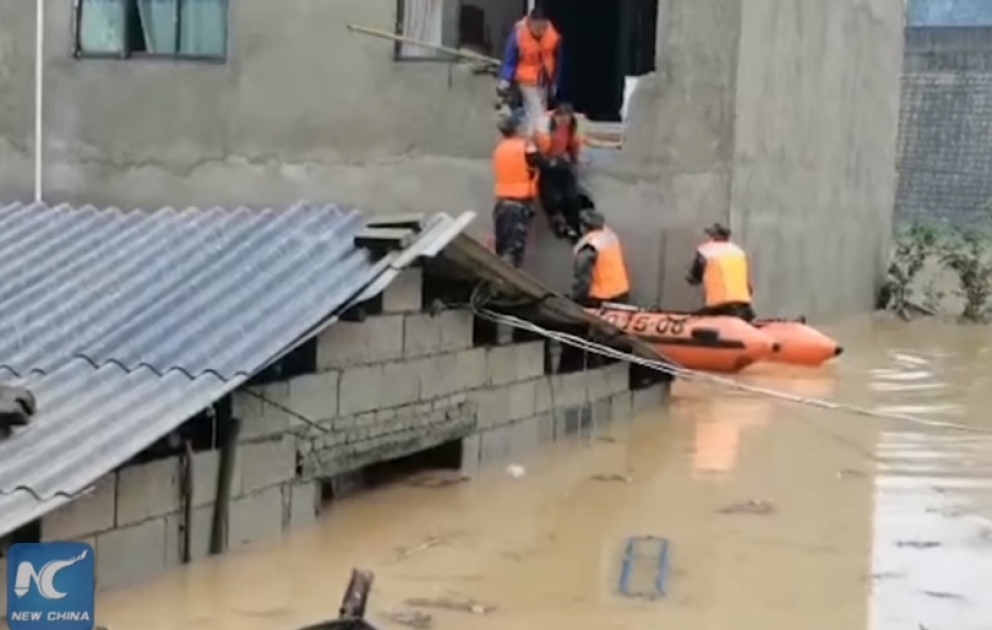 Firefighter uses his back as bridge for trapped villagers in flood