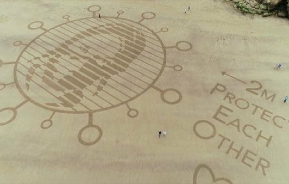 Dessins géants de sable contre le covid-19