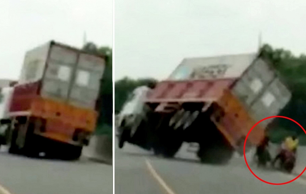 A motorcyclist cheats death after narrowly avoiding a crashing truck