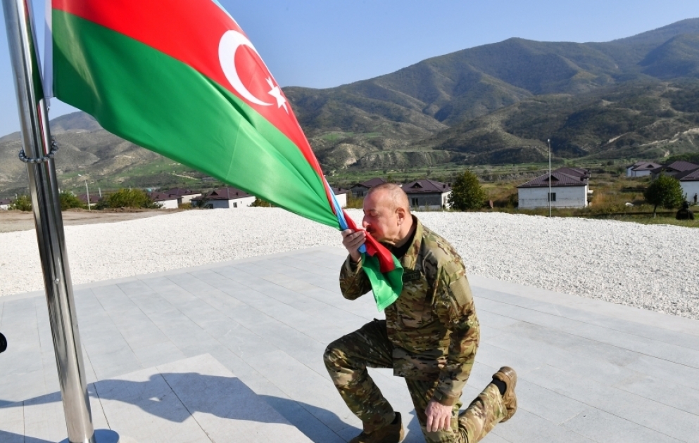 Präsident Ilham Aliyev hisst aserbaidschanische Flagge in Chodschali